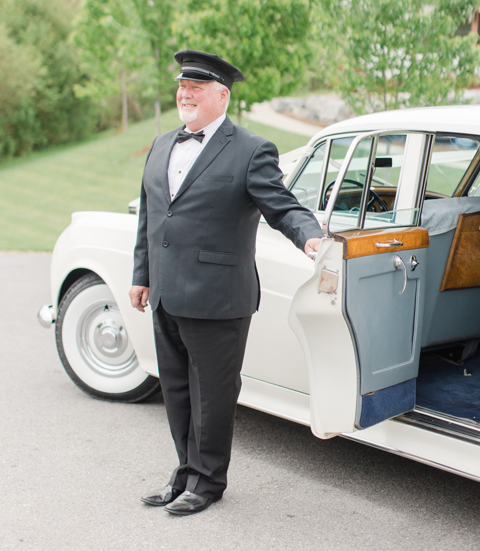 Chauffeur opening door of Rolls-Royce